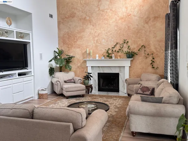 a living room with furniture a flat screen tv and a fireplace