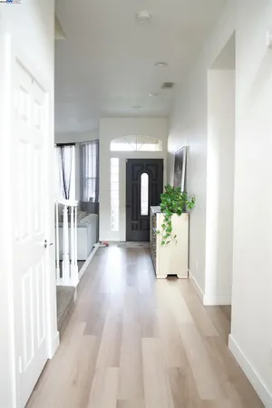 a view of a hallway to an empty room and wooden floor