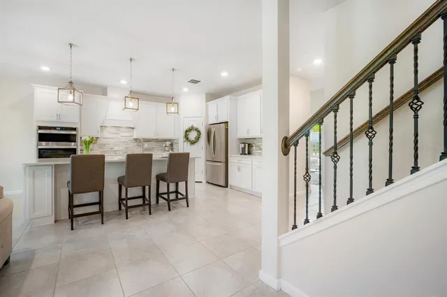 a dining hall with stainless steel appliances a dining table chairs and view kitchen