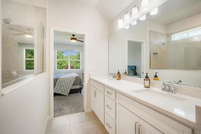 a spacious en suite bathroom with a double vanity sink mirror and a bathtub
