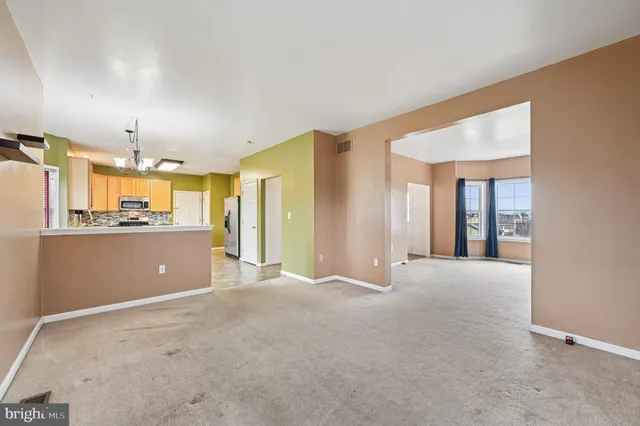 a kitchen with stainless steel appliances granite countertop a stove top oven a sink dishwasher a dining table and chairs with wooden floor