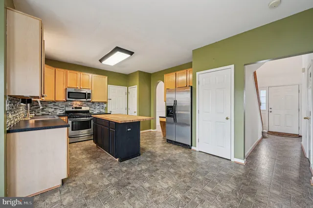 a kitchen with kitchen island a sink table and chairs