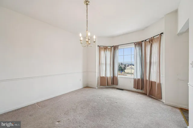 a view of a big room with windows and chandelier fan