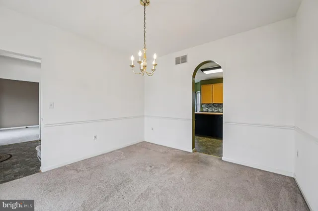 a view of an empty room with closet and wooden door