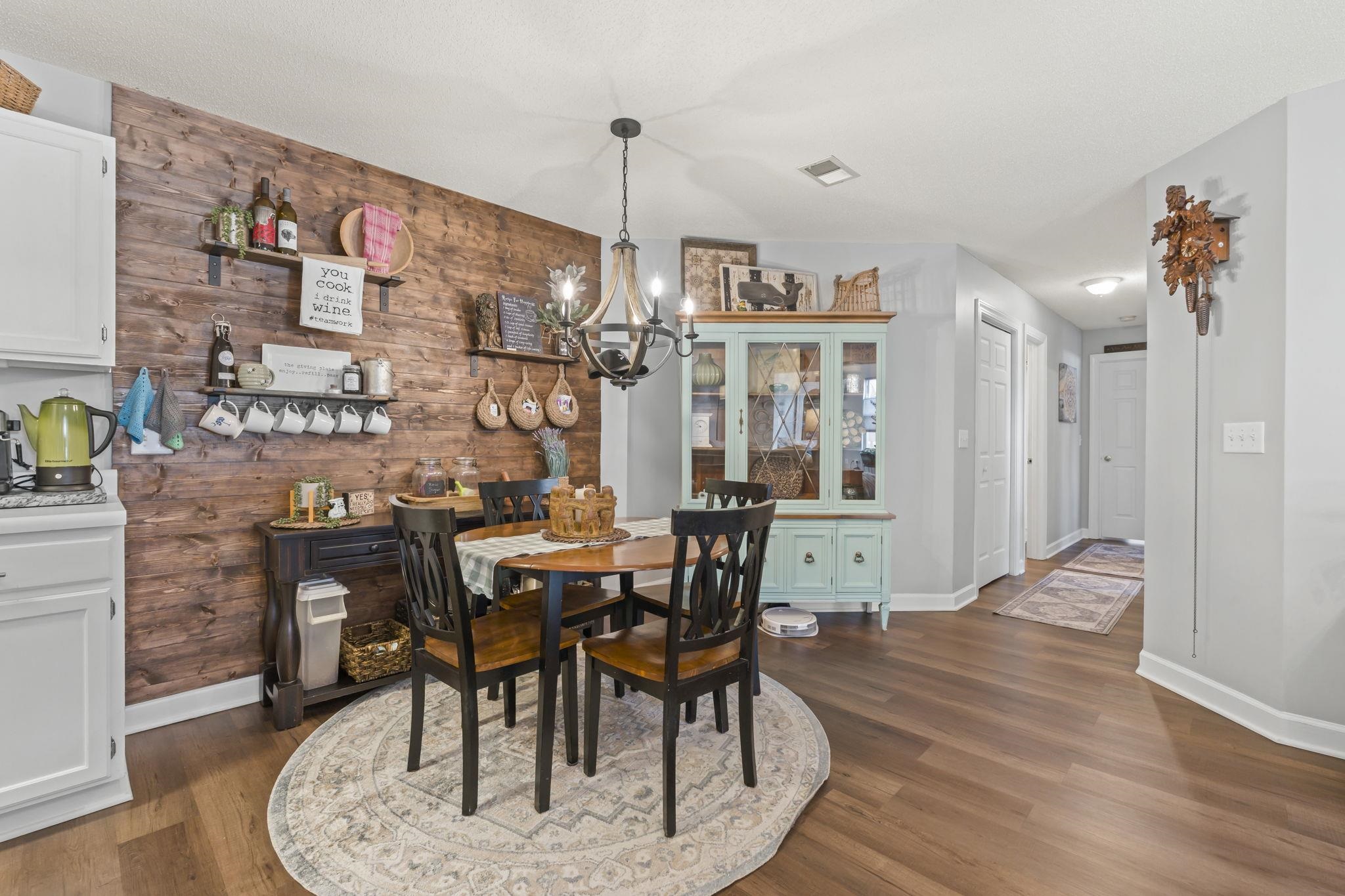 4383 Daphne Lane, Unit F Murrells Inlet, SC 29576 - Photo 11 of 35 Dining area with a chandelier, wood walls, and dark wood-style floors