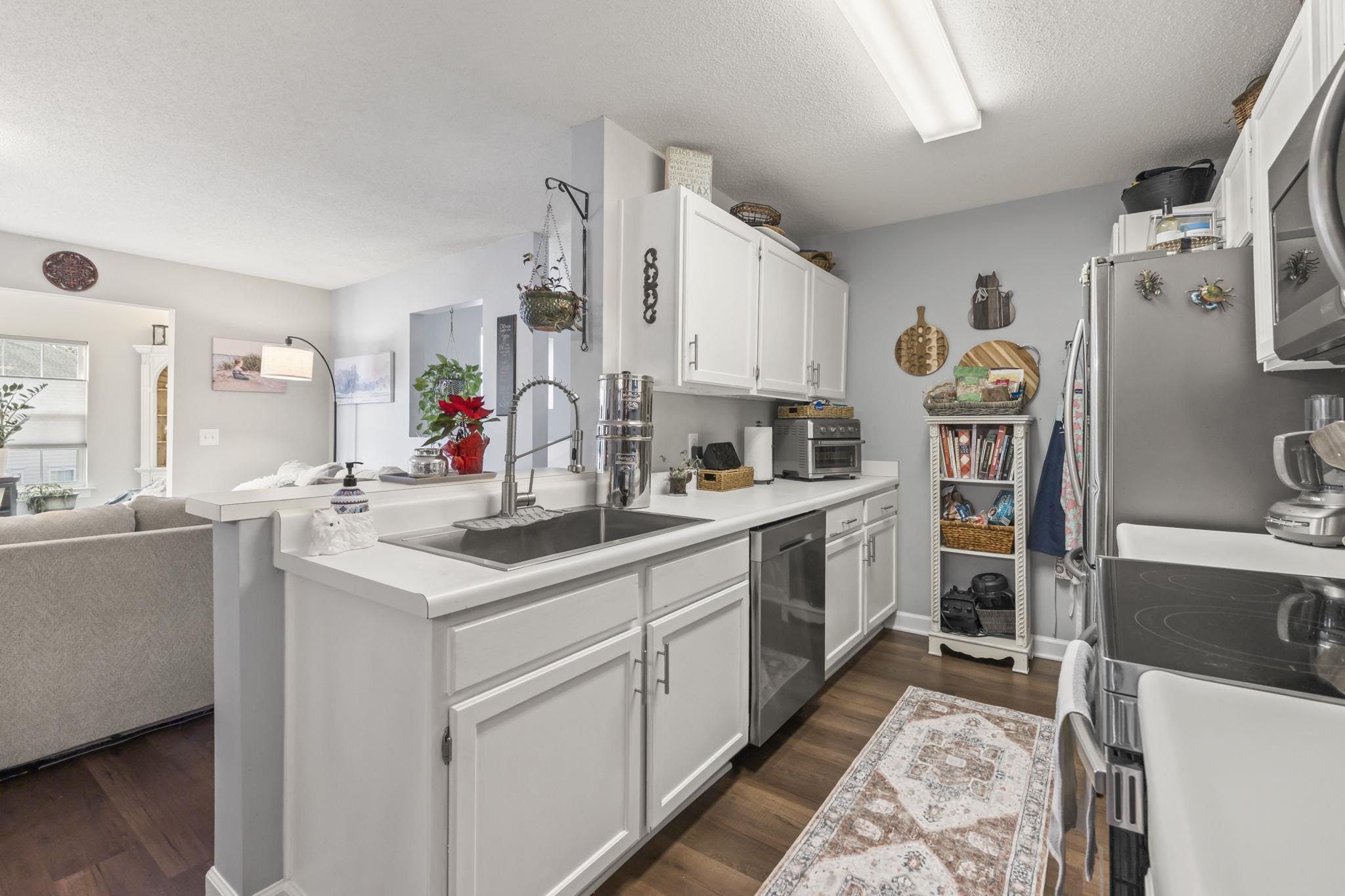 4383 Daphne Lane, Unit F Murrells Inlet, SC 29576 - Photo 35 of 35 Kitchen with open floor plan, white cabinetry, stainless steel appliances, light countertops, and dark wood finished floors