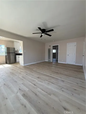 a view of a livingroom with a ceiling fan and wooden floor