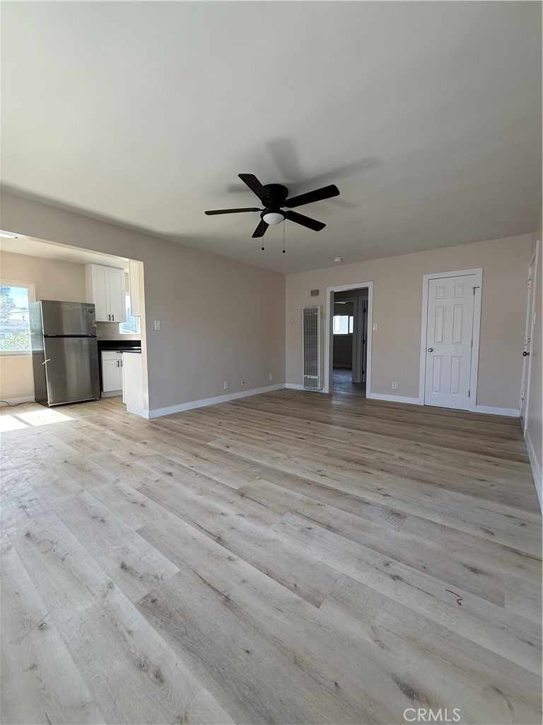 10018 Foster Road, Unit 10020 (1/2) Bellflower, CA 90706 - Photo 1 of 8 a view of a livingroom with a ceiling fan and wooden floor