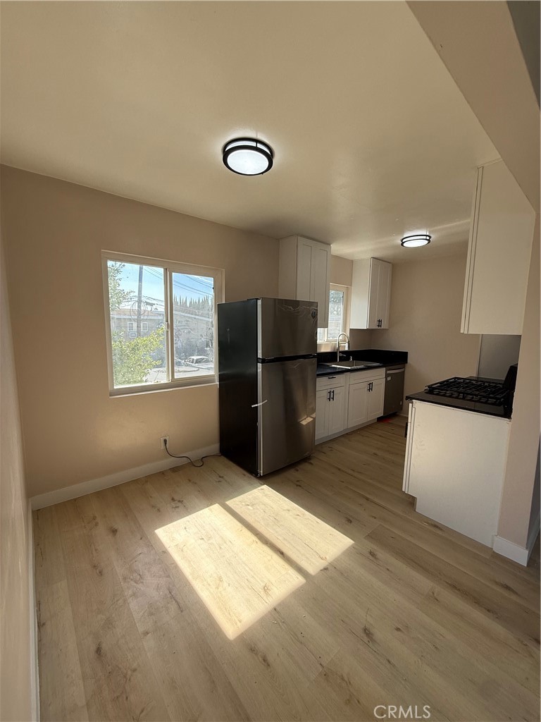 10018 Foster Road, Unit 10020 (1/2) Bellflower, CA 90706 - Photo 2 of 8 a kitchen with stainless steel appliances granite countertop a refrigerator and a stove top oven