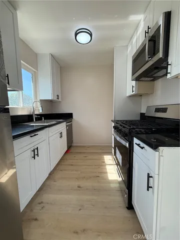 a kitchen with stainless steel appliances granite countertop a sink and a stove