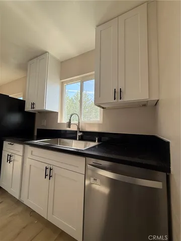 a kitchen with white cabinets and black appliances