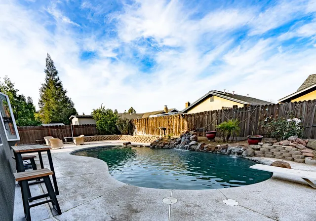 a view of a patio with table and chairs with wooden fence
