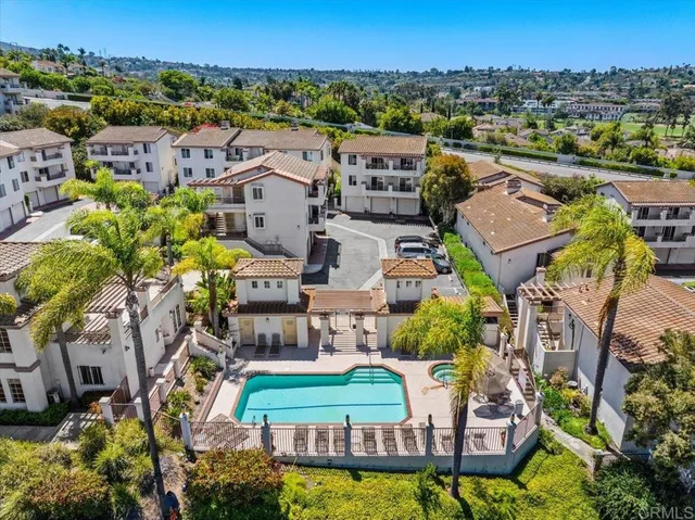 an aerial view of residential houses with outdoor space and swimming pool