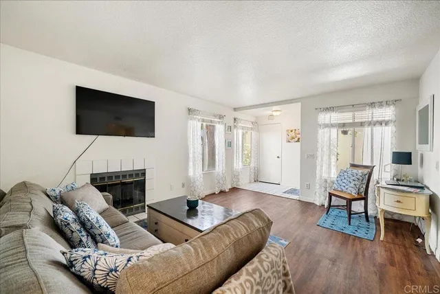 a living room with furniture a fireplace and a flat screen tv