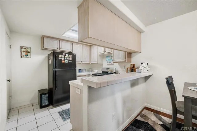 a kitchen with a sink a refrigerator and cabinets