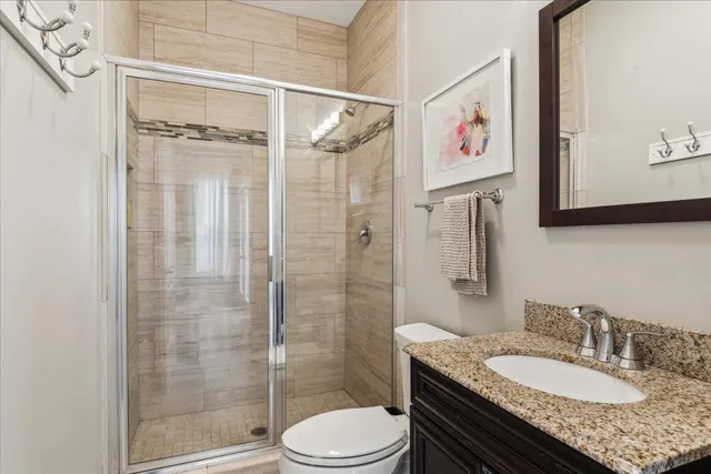 a bathroom with a granite countertop sink toilet and shower
