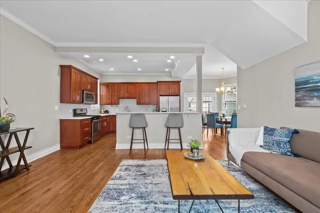 a living room with stainless steel appliances kitchen island granite countertop a rug kitchen view and a table