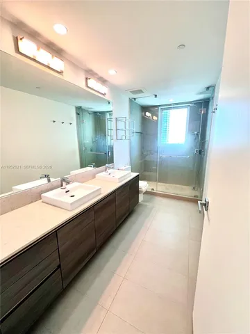 a bathroom with a double vanity sink and mirror
