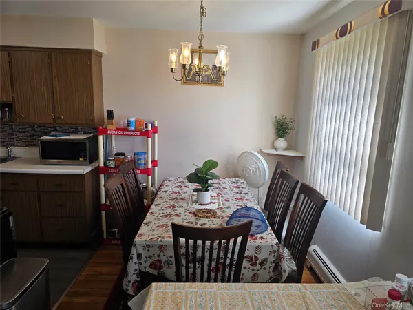 a view of a dining room with furniture a chandelier and wooden floor