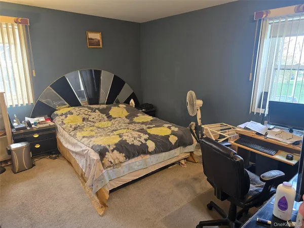 a bedroom with a bed chair and window