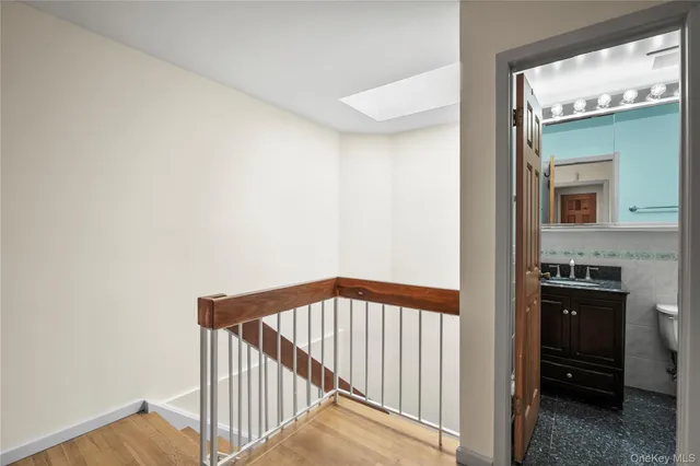 a view of a hallway and a kitchen space with wooden floor