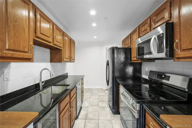a kitchen with stainless steel appliances granite countertop a sink stove and refrigerator