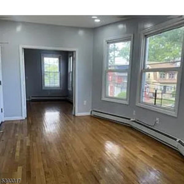 82 Scheerer Avenue, Unit 2 Newark, NJ 07112 - Photo 4 of 7 a view of an empty room with wooden floor and a window
