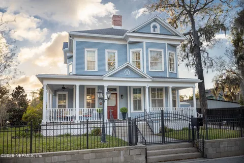 a view of a dining room with furniture a chandelier and wooden floor