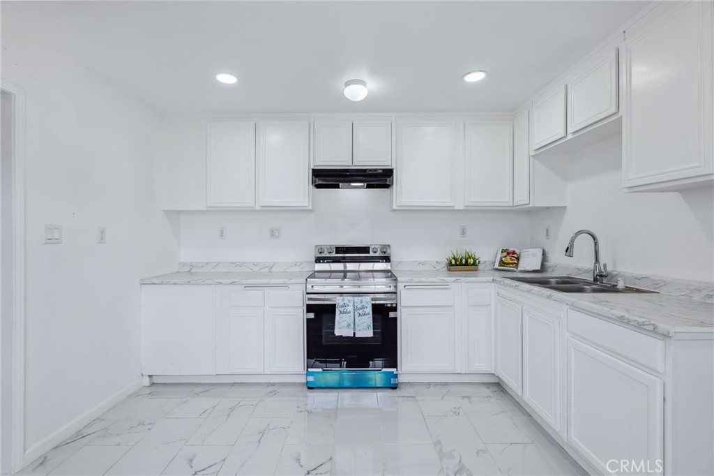 501 B Street Needles, CA 92363 - Photo 11 of 32 a kitchen with granite countertop a stove sink and cabinets