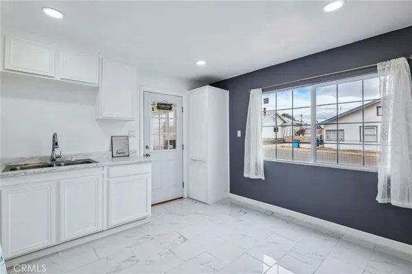 a kitchen with white cabinets and sink
