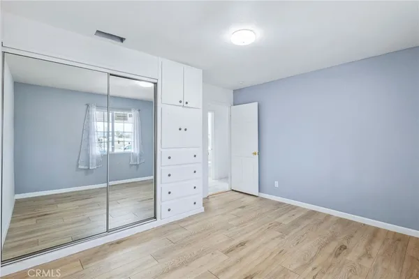 an empty room with wooden floor and cabinet