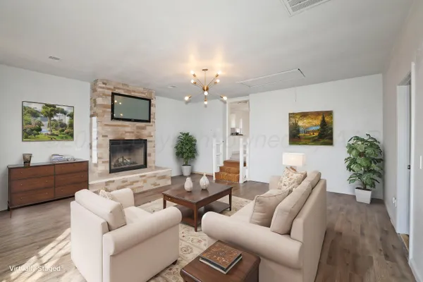 a living room with furniture a fireplace and a flat screen tv
