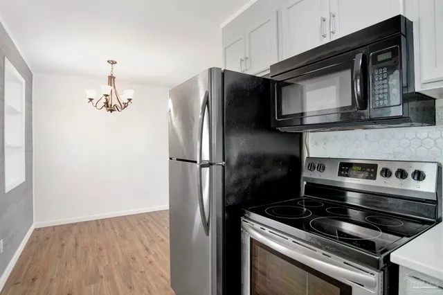a kitchen with granite countertop a stove and a microwave