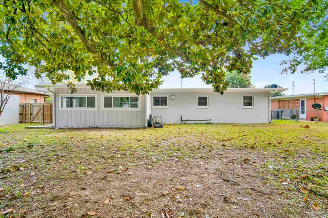 a front view of house with yard and trees around