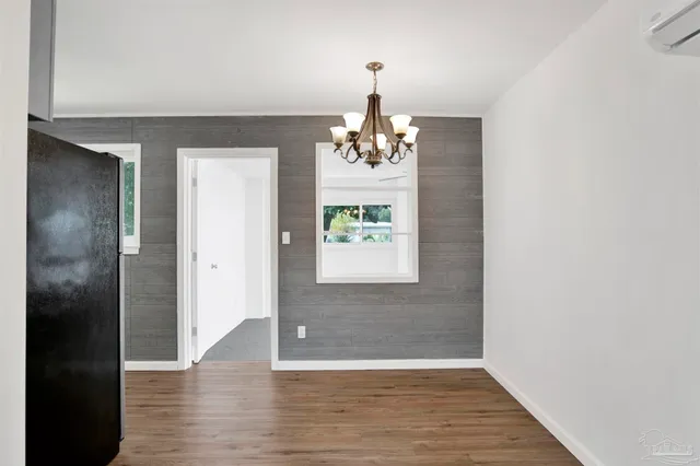a view of a hallway with windows and chandelier
