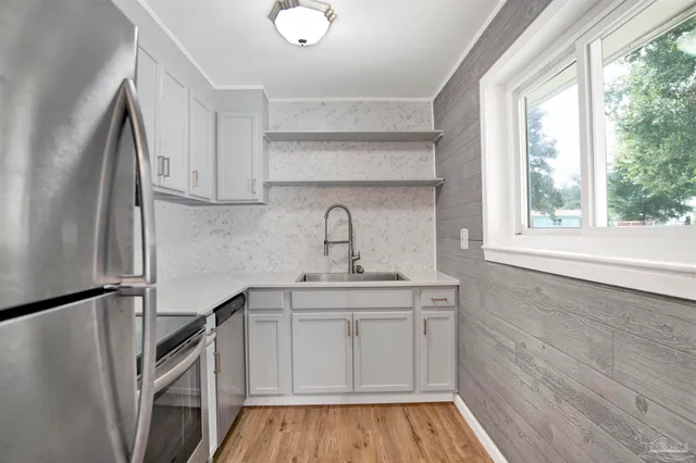 a kitchen with a sink a refrigerator and window