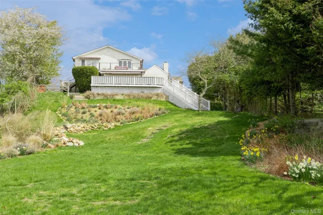 a view of a house with a big yard and large trees