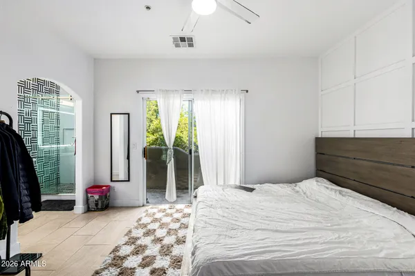 a bedroom with a bed dresser and a chandelier