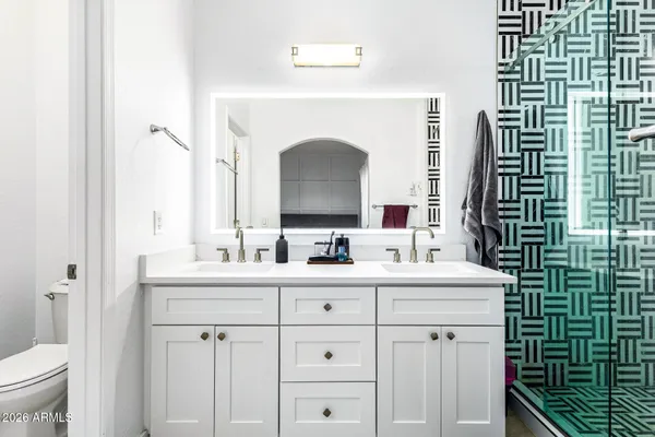 a bathroom with a double vanity sink toilet and a mirror