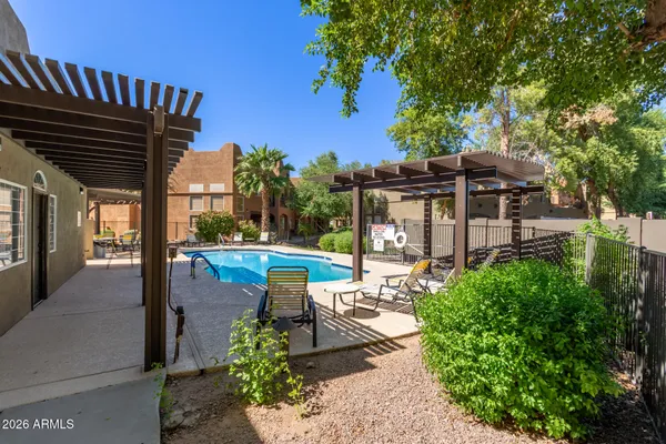 a view of a patio with table and chairs potted plants and large tree