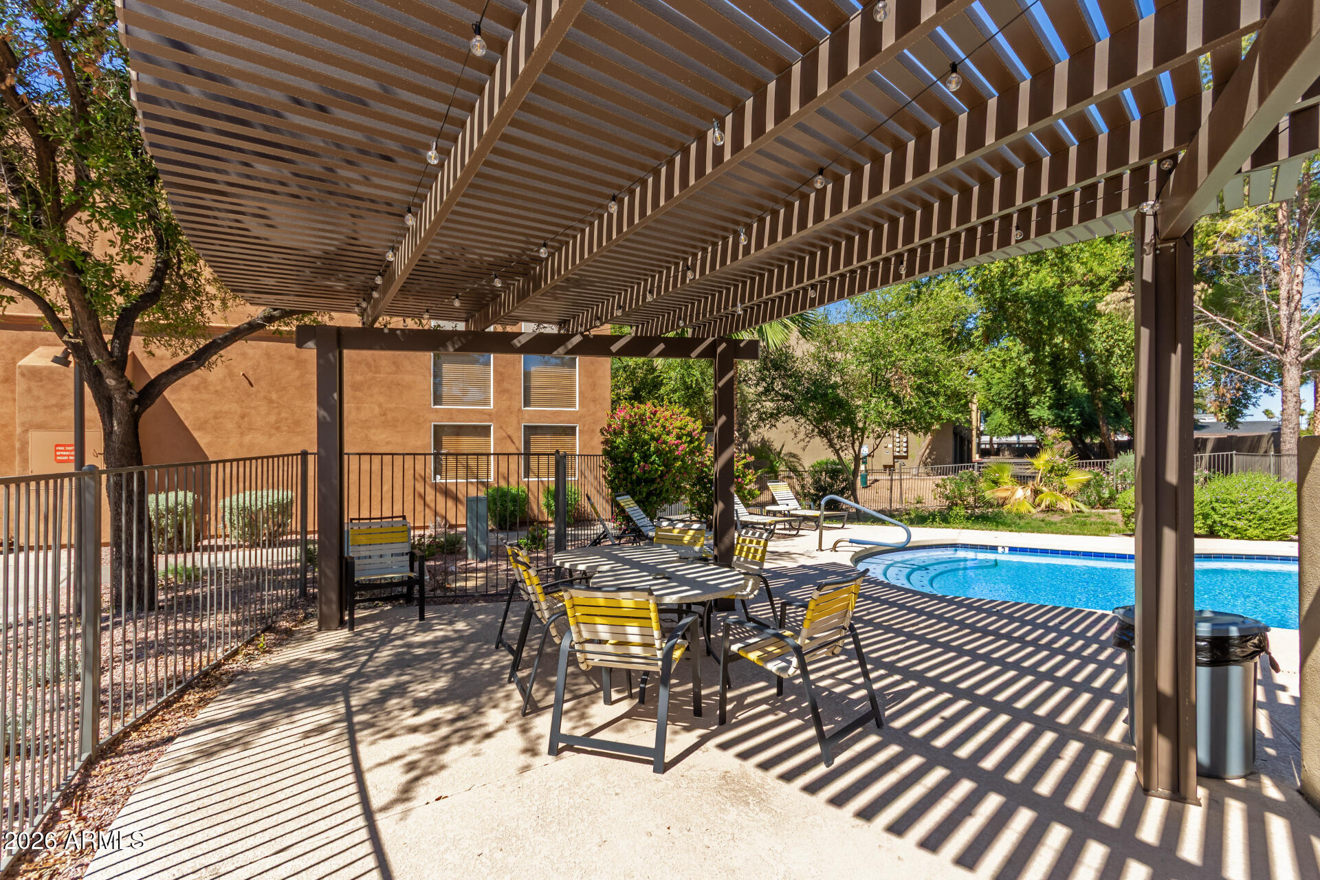 1718 West Colter Street, Unit 115 Phoenix, AZ 85015 - Photo 22 of 26 a view of a swimming pool with chairs in patio
