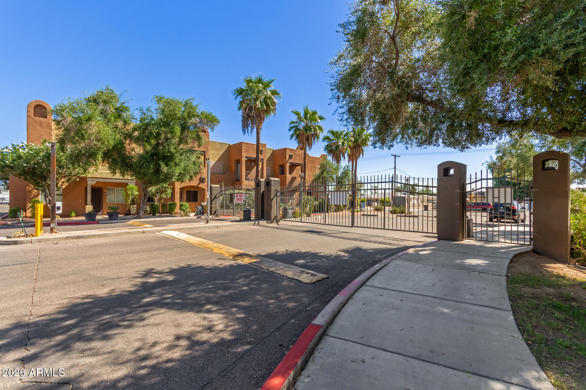 1718 West Colter Street, Unit 115 Phoenix, AZ 85015 - Photo 23 of 26 a view of street with a building and trees in the background