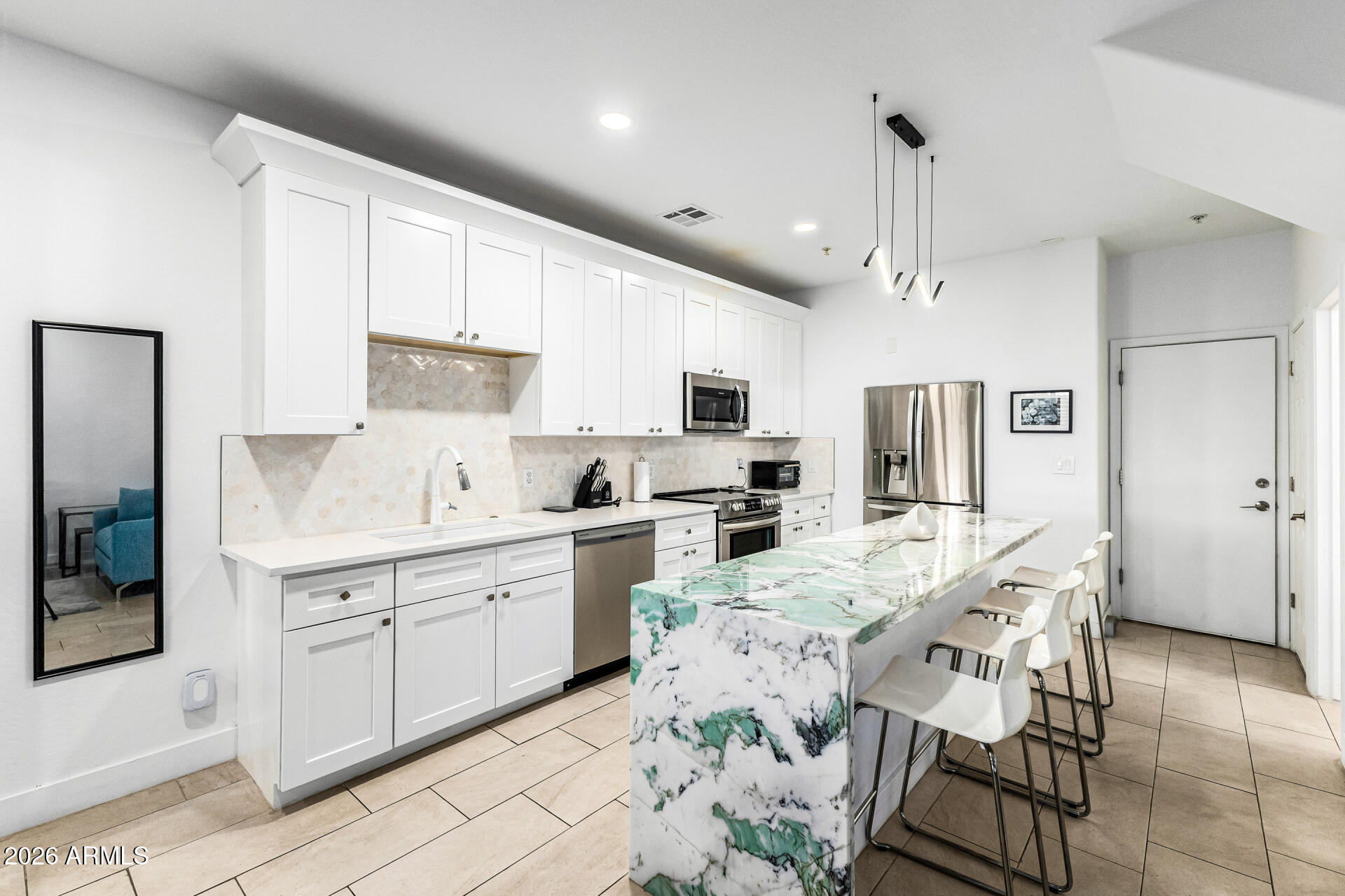 1718 West Colter Street, Unit 115 Phoenix, AZ 85015 - Photo 8 of 26 a kitchen with white cabinets and refrigerator