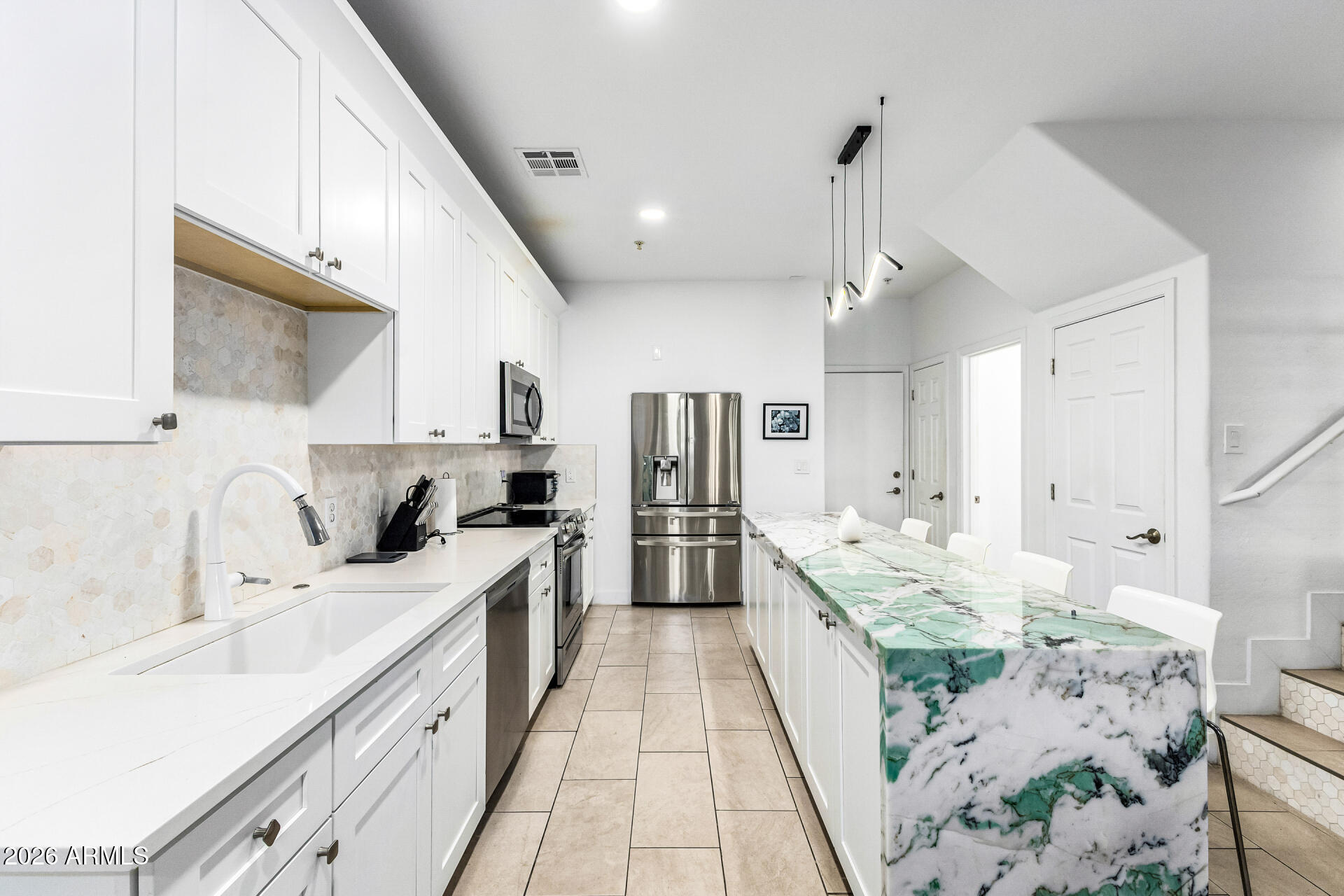 1718 West Colter Street, Unit 115 Phoenix, AZ 85015 - Photo 10 of 26 a large white kitchen with kitchen island a sink stove and refrigerator
