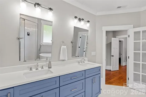 a bathroom with double vanity sinks and a mirror