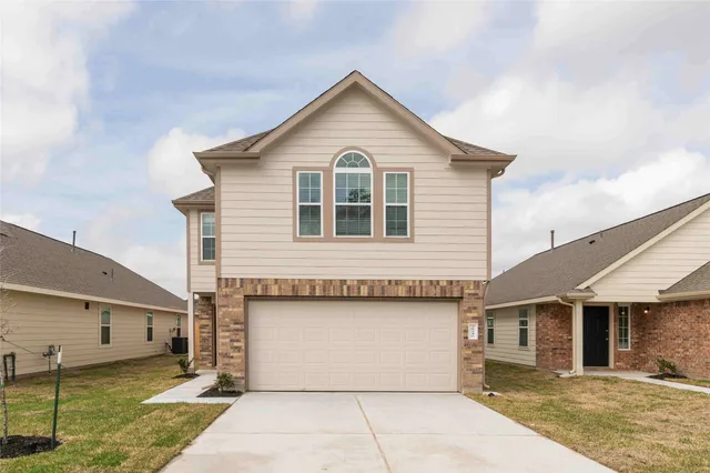 a front view of a house with a yard and garage