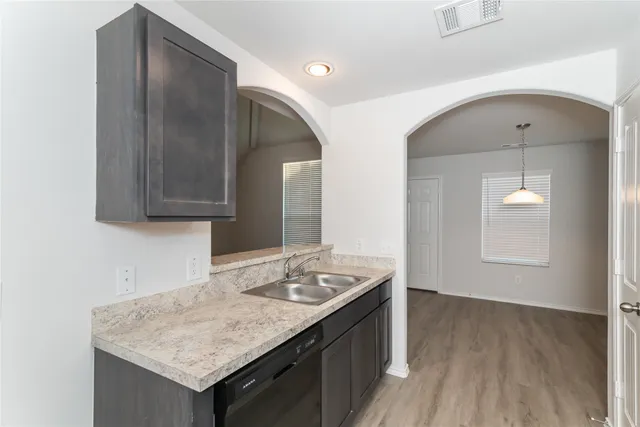 a kitchen with a sink cabinets and a wooden floor