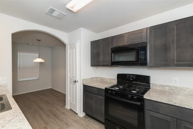 a kitchen with granite countertop stainless steel appliances and wooden cabinets