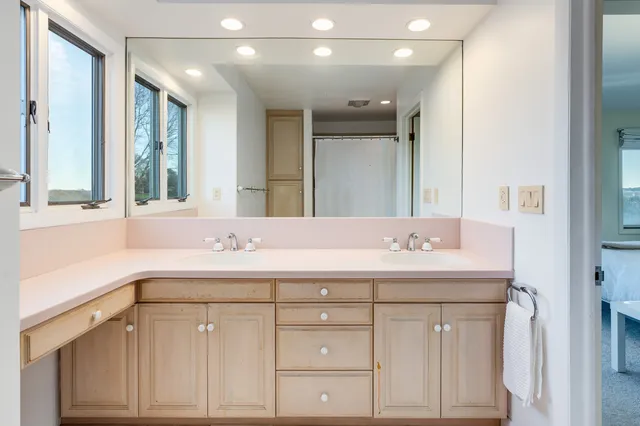 a bathroom with a sink a vanity a large mirror and a shower