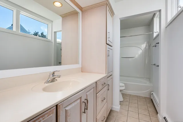 a bedroom with a bed and a dresser next to a window